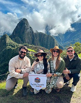 grupo de amigos com a bandeira da Machu Viagens em Machu Picchu