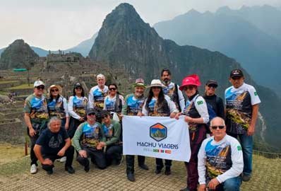 grupo de turistas com a bandera da Machu Viagens Peru